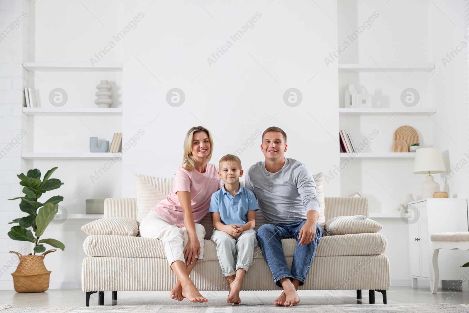 Happy parents and their son on sofa at home Photo of Happy parents and their son on sofa at home