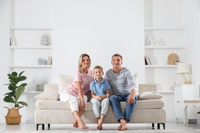 Photo of Happy parents and their son on sofa at home