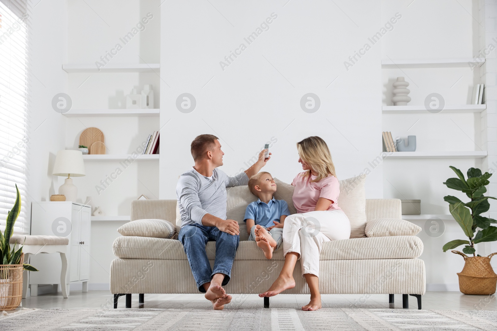 Photo of Family using remote to control air conditioner at home