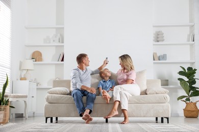 Photo of Family using remote to control air conditioner at home