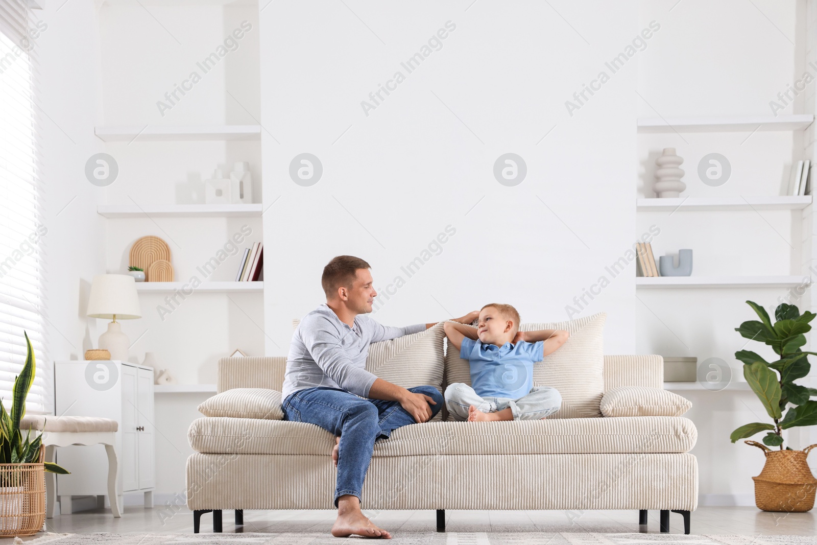 Father and his son spending time together on sofa at home Photo of Father and his son spending time together on sofa at home