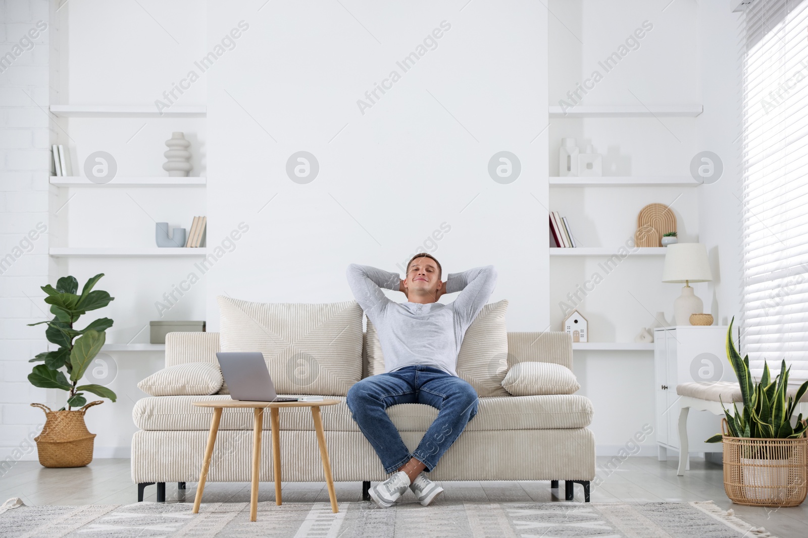 Young man relaxing on sofa at home Photo of Young man relaxing on sofa at home