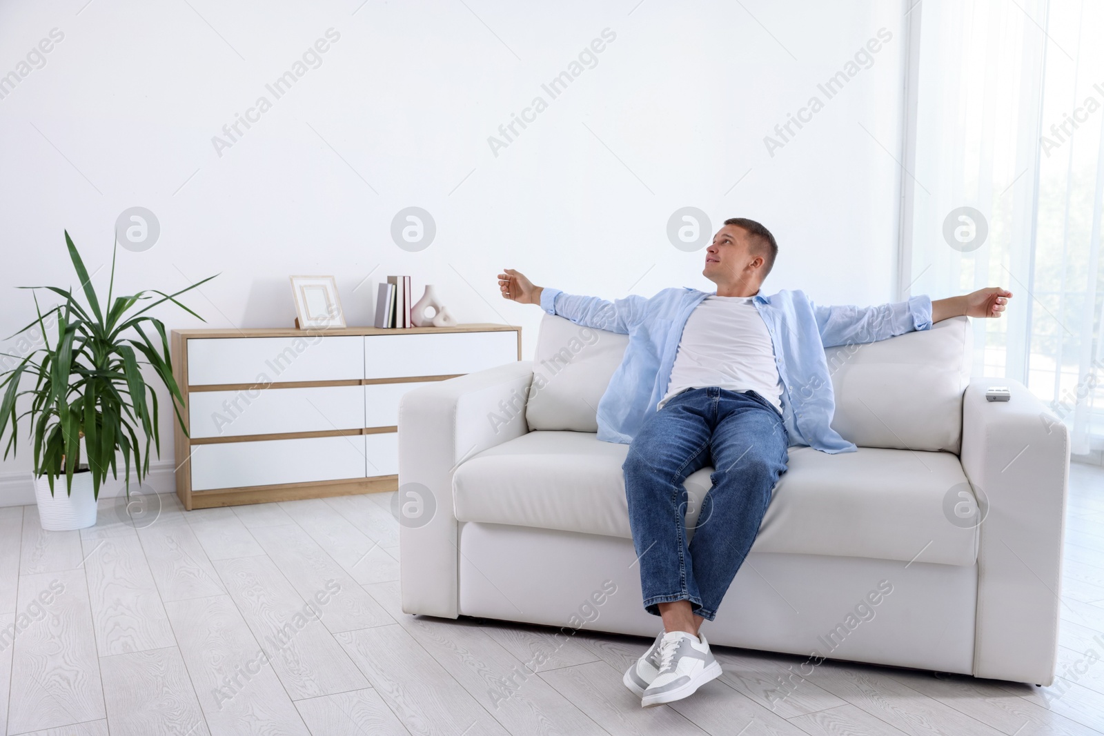 Photo of Young man relaxing on sofa at home
