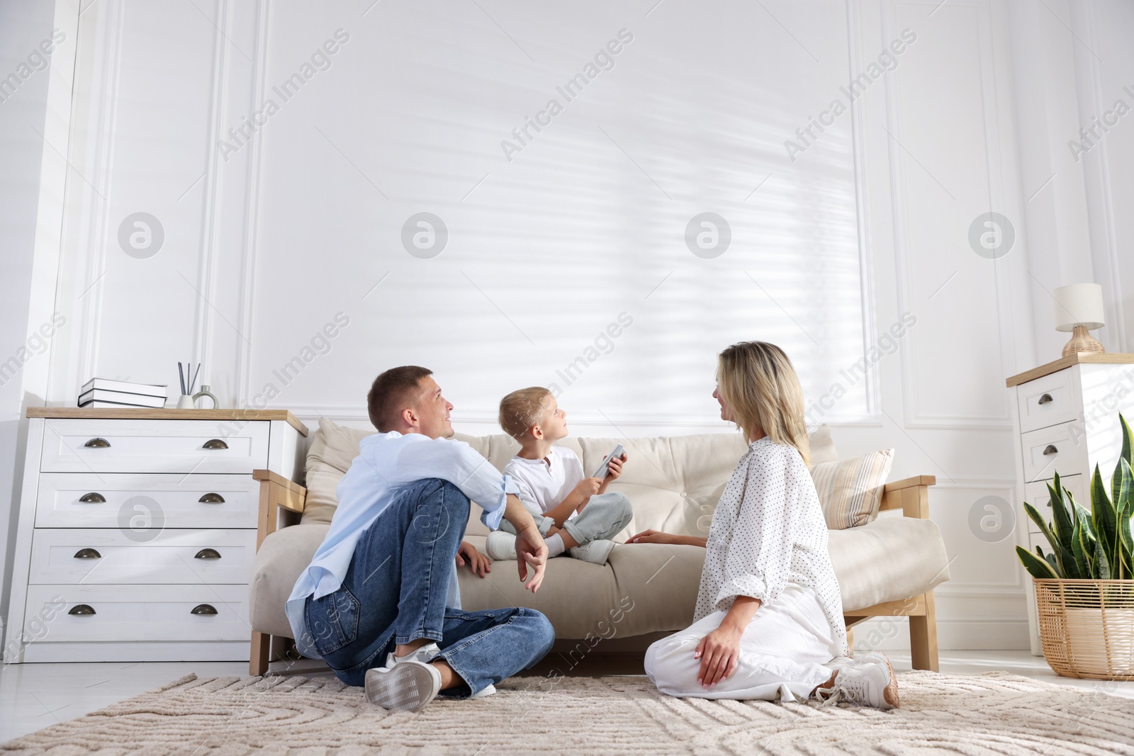 Photo of Family using remote to control air conditioner at home