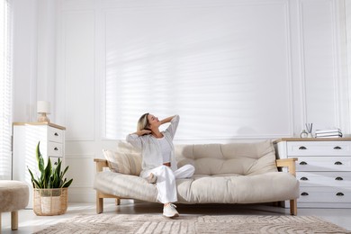 Photo of Beautiful woman relaxing on sofa at home