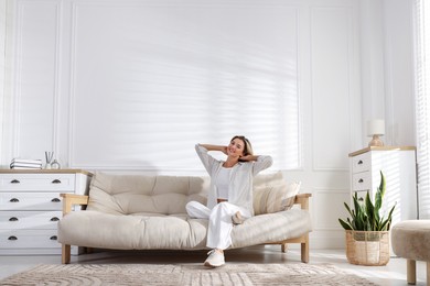 Photo of Beautiful woman relaxing on sofa at home