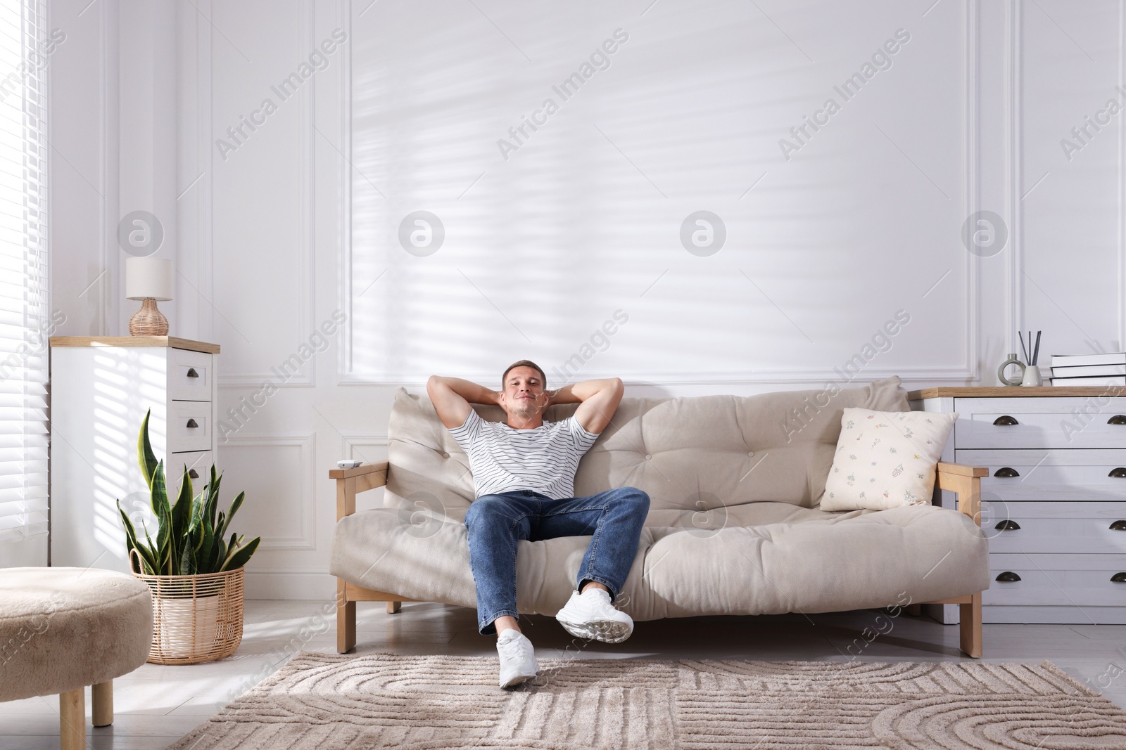 Photo of Young man relaxing on sofa at home