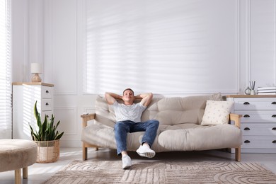 Photo of Young man relaxing on sofa at home