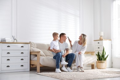 Photo of Family using remote to control air conditioner at home