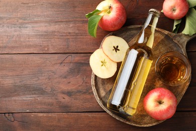 Photo of Delicious cider in bottle, glass and apples on wooden table, flat lay. Space for text