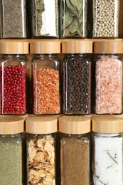 Photo of Different spices and jars on wooden background, closeup