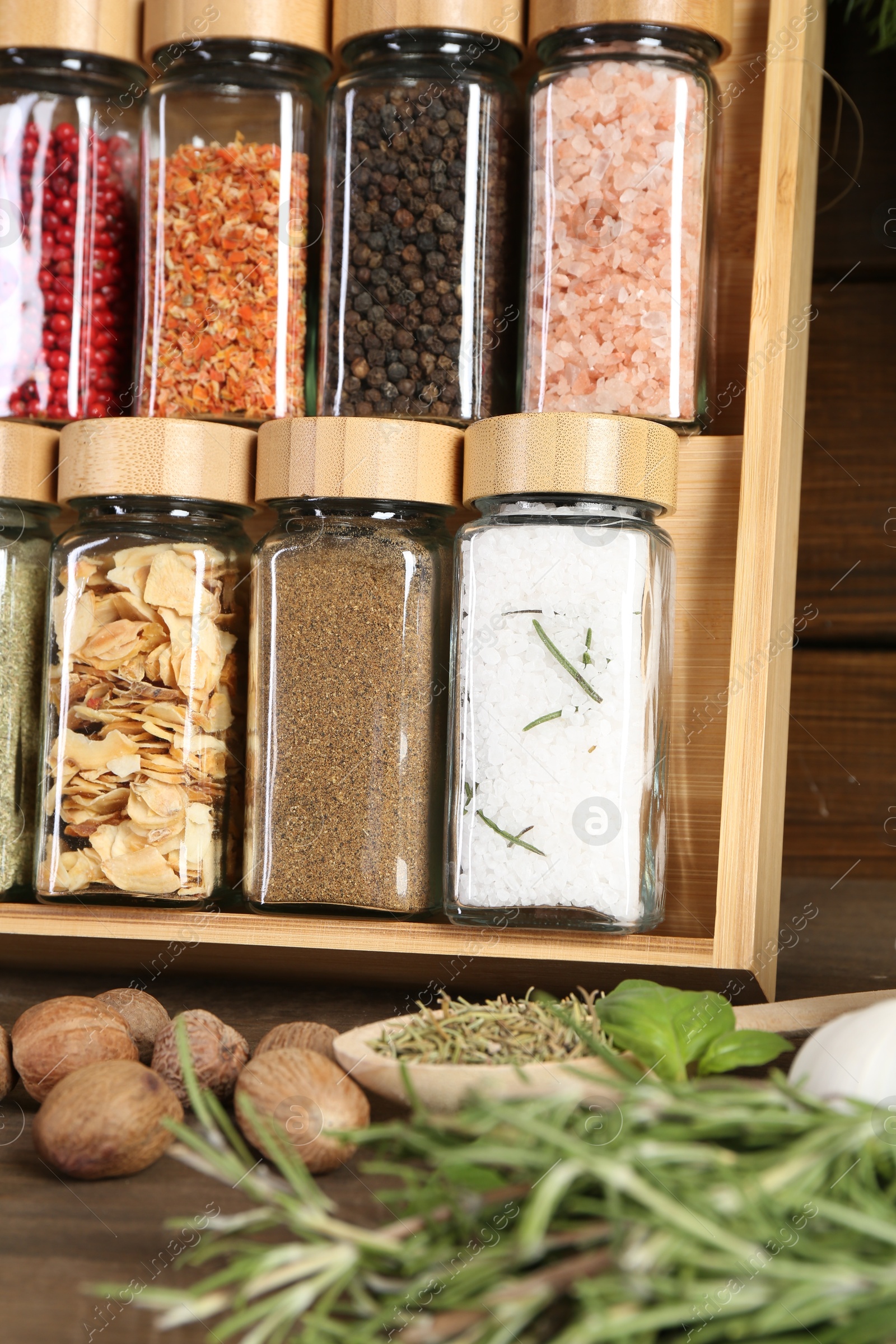 Photo of Different spices and jars on wooden table, closeup