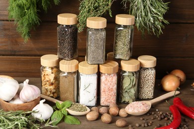 Photo of Different spices and jars on wooden table