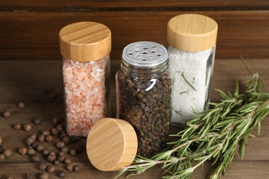 Photo of Different spices and jars on wooden table, closeup
