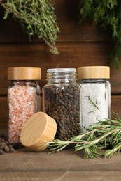 Photo of Different spices and jars on wooden table, closeup