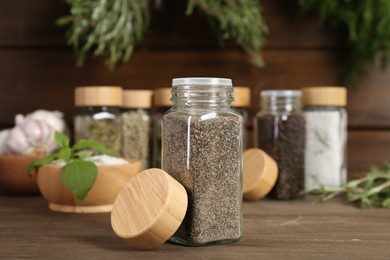 Photo of Different spices and jars on wooden table, selective focus