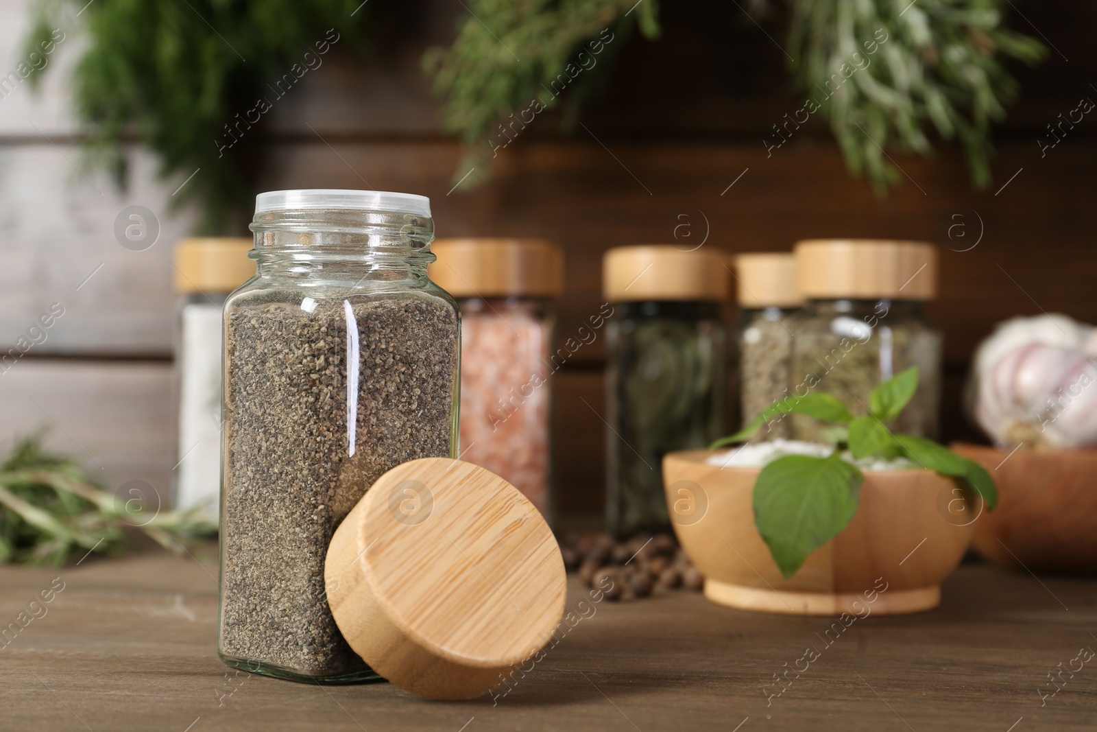 Photo of Different spices and jars on wooden table, selective focus
