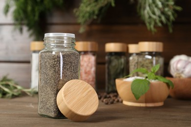 Photo of Different spices and jars on wooden table, selective focus