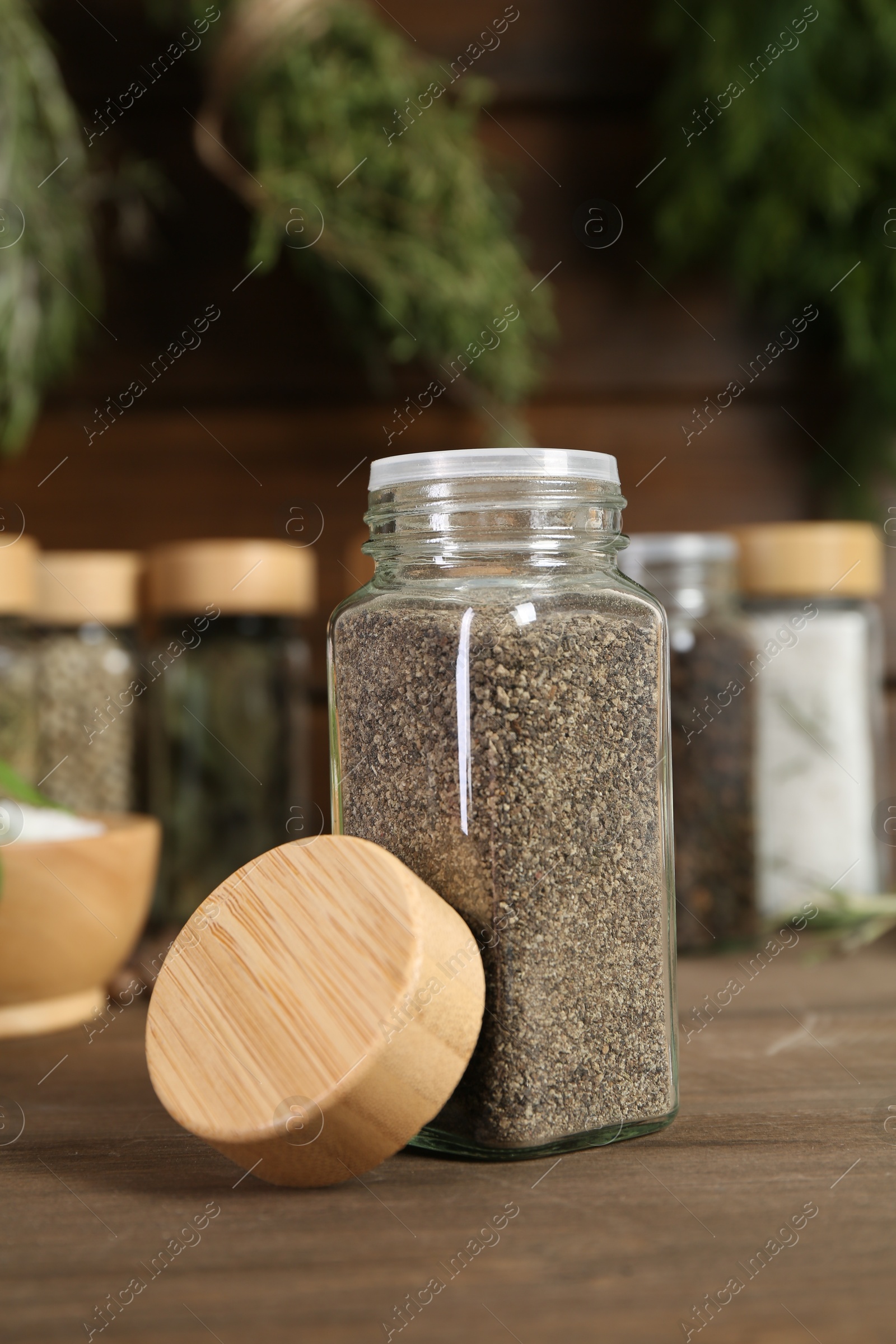 Different spices and jars on wooden table, selective focus Photo of Different spices and jars on wooden table, selective focus