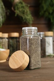 Photo of Different spices and jars on wooden table, selective focus