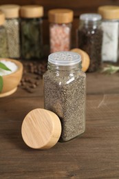 Photo of Different spices and jars on wooden table, selective focus