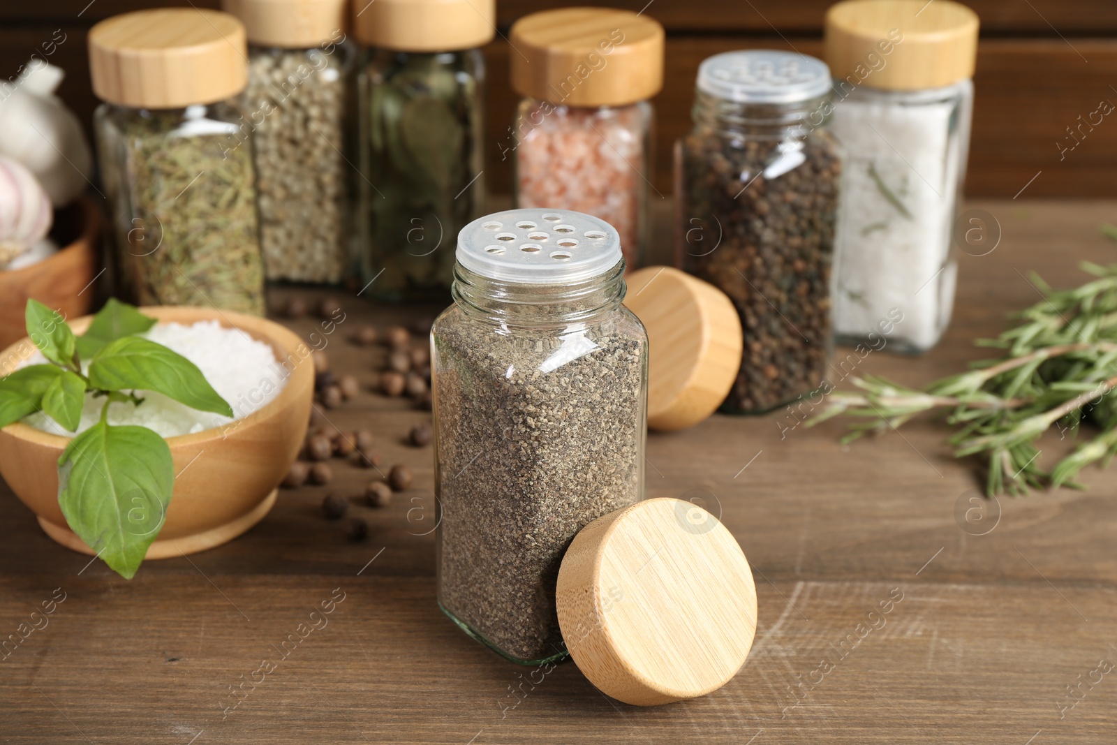 Different spices and jars on wooden table, selective focus Photo of Different spices and jars on wooden table, selective focus
