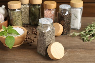 Photo of Different spices and jars on wooden table, selective focus