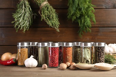 Photo of Different spices and jars on wooden table