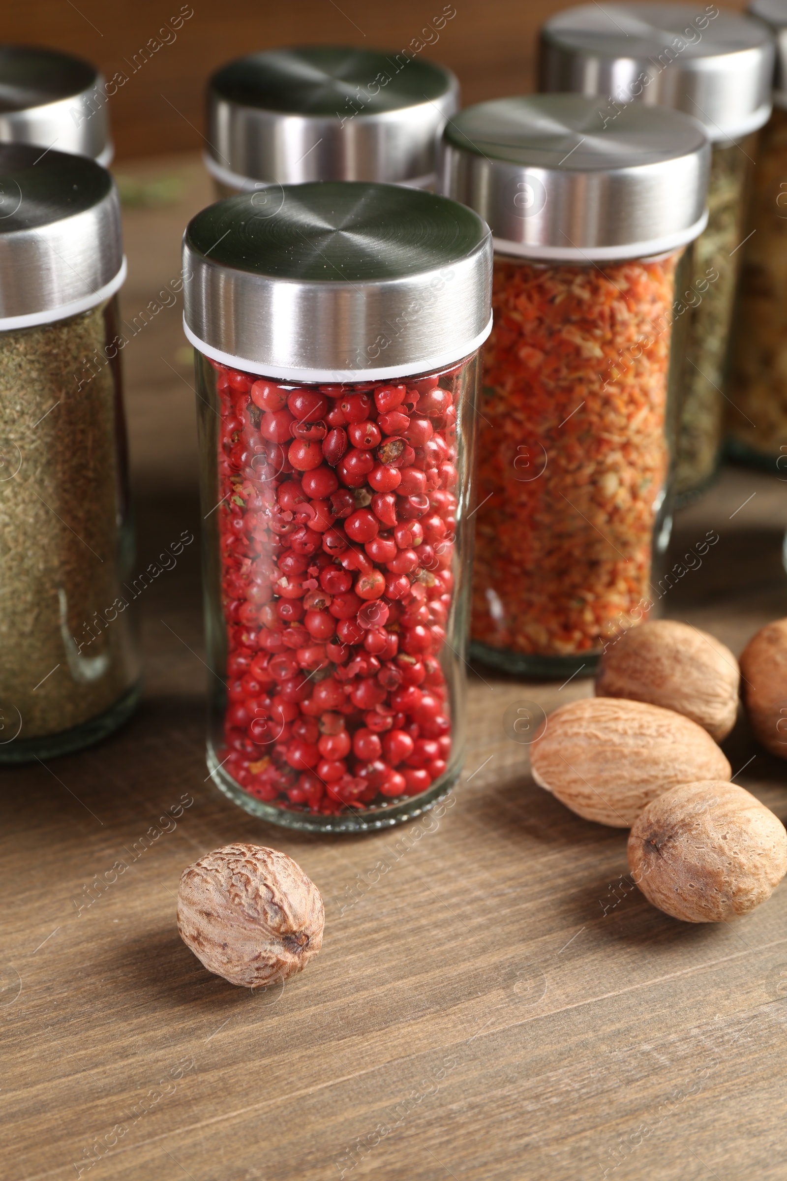 Different spices and jars on wooden table, closeup Photo of Different spices and jars on wooden table, closeup