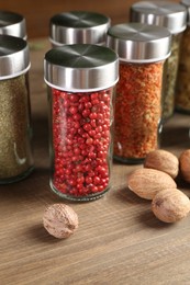 Photo of Different spices and jars on wooden table, closeup