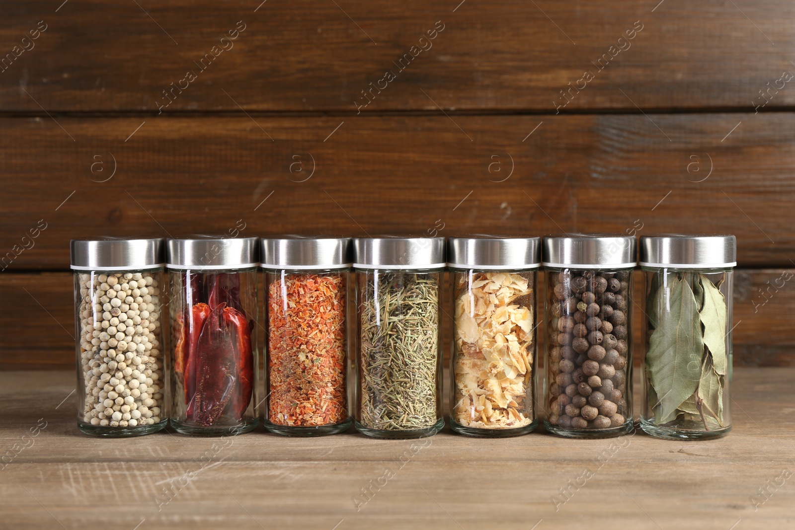 Photo of Different spices and jars on wooden table