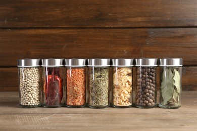 Photo of Different spices and jars on wooden table