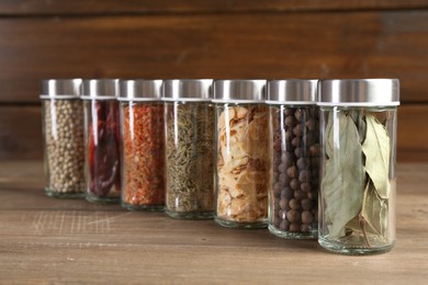 Photo of Different spices and jars on wooden table