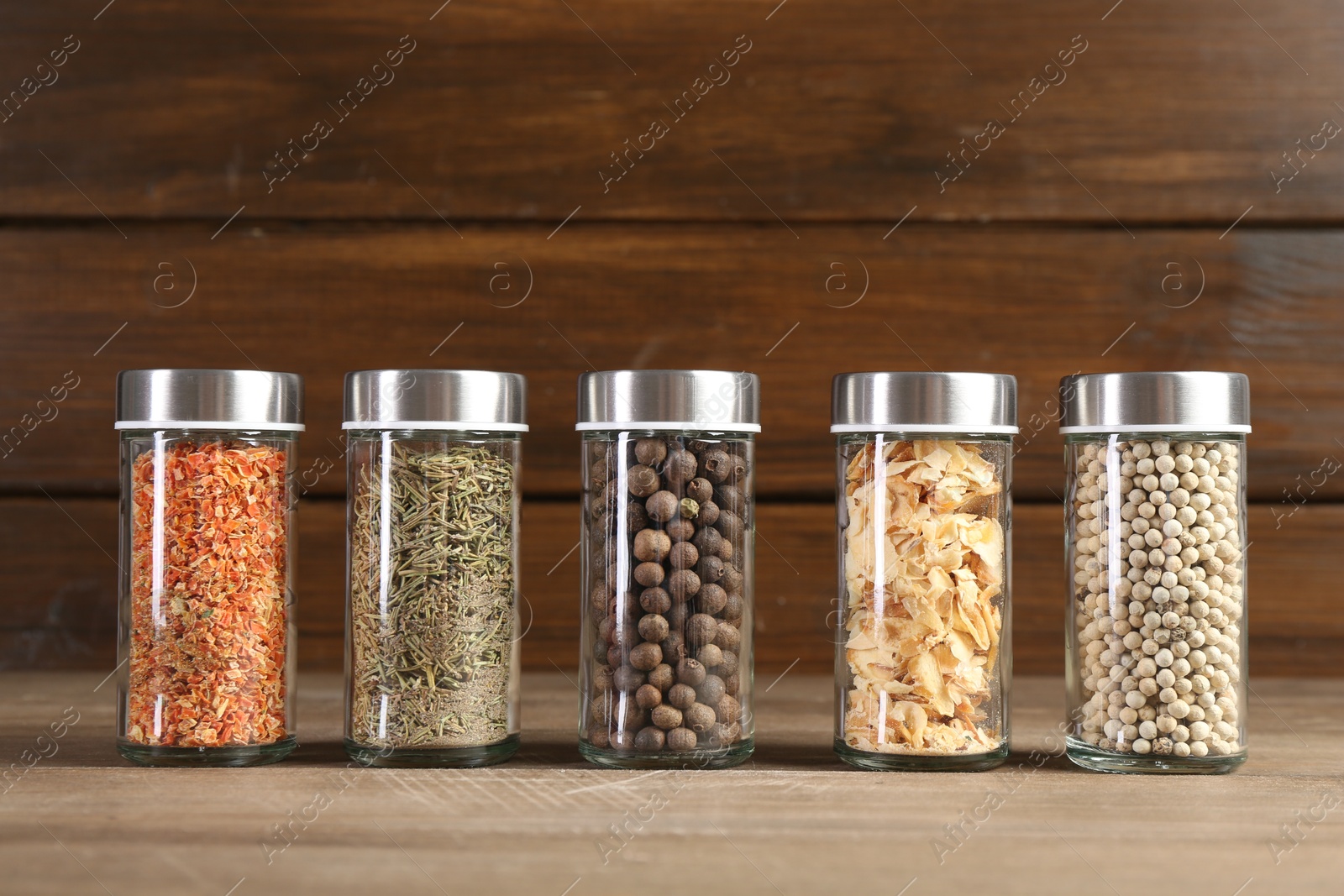 Photo of Different spices and jars on wooden table