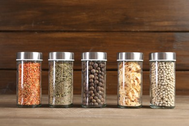 Photo of Different spices and jars on wooden table