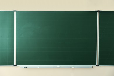 Photo of Green chalkboard on wall in classroom. Back to school