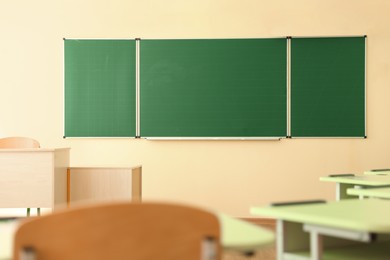 Photo of Green chalkboard on wall in classroom. Back to school