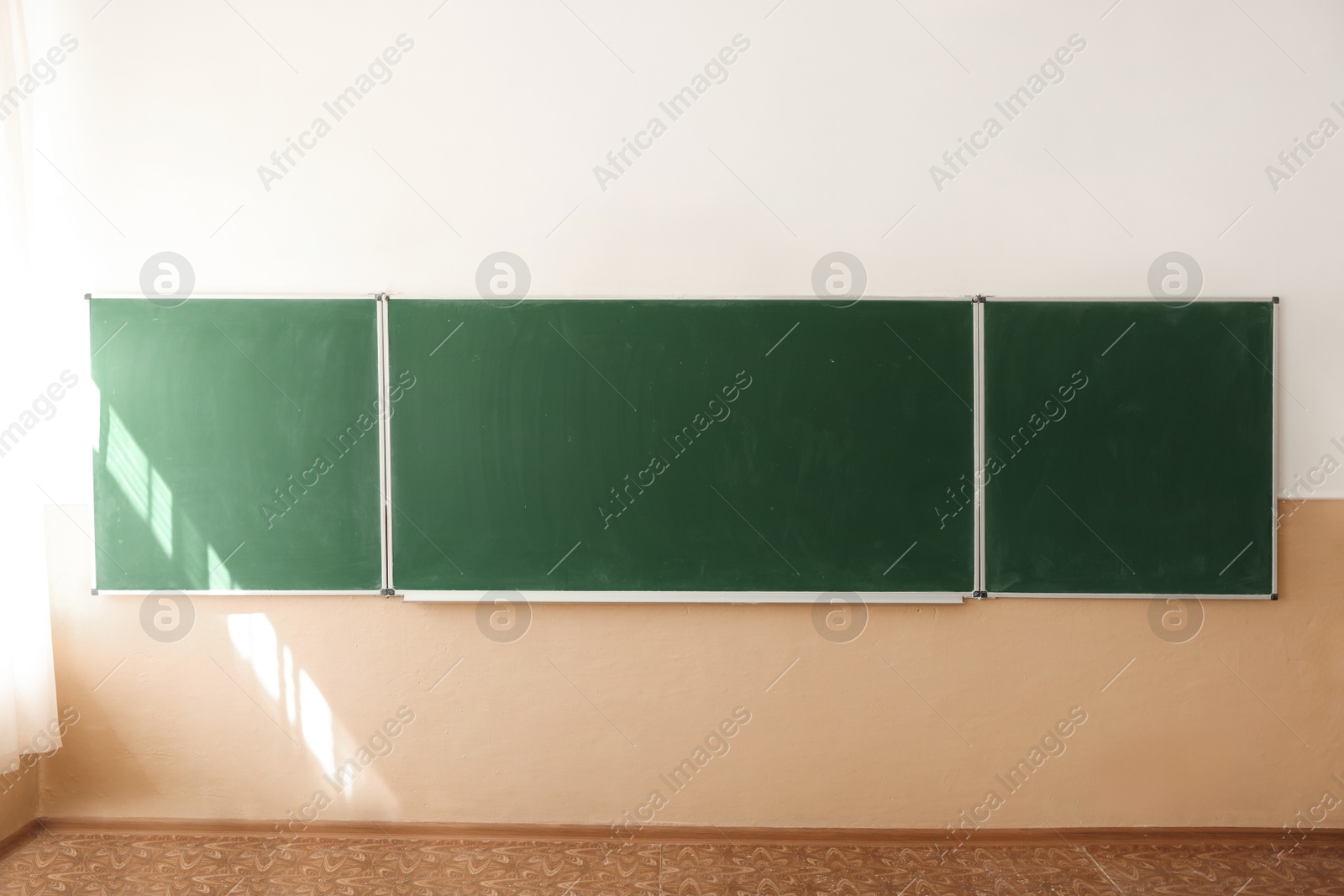 Photo of Green chalkboard on wall in classroom. Back to school