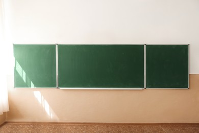 Photo of Green chalkboard on wall in classroom. Back to school