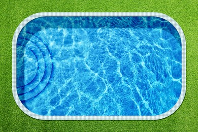 Image of Swimming pool surrounded by green grass, top view