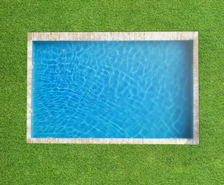 Image of Swimming pool surrounded by green grass, top view