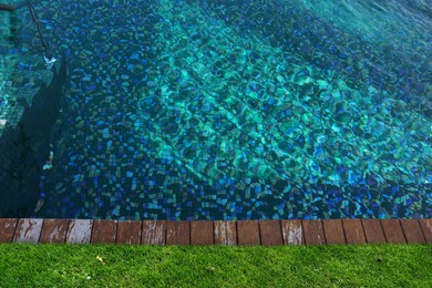 Image of Swimming pool surrounded by green grass, top view