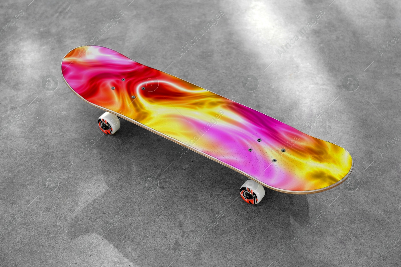 Skateboard with colorful pattern on grey textured surface Image of Skateboard with colorful pattern on grey textured surface