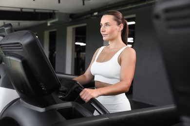 Photo of Athletic woman training on treadmill in gym