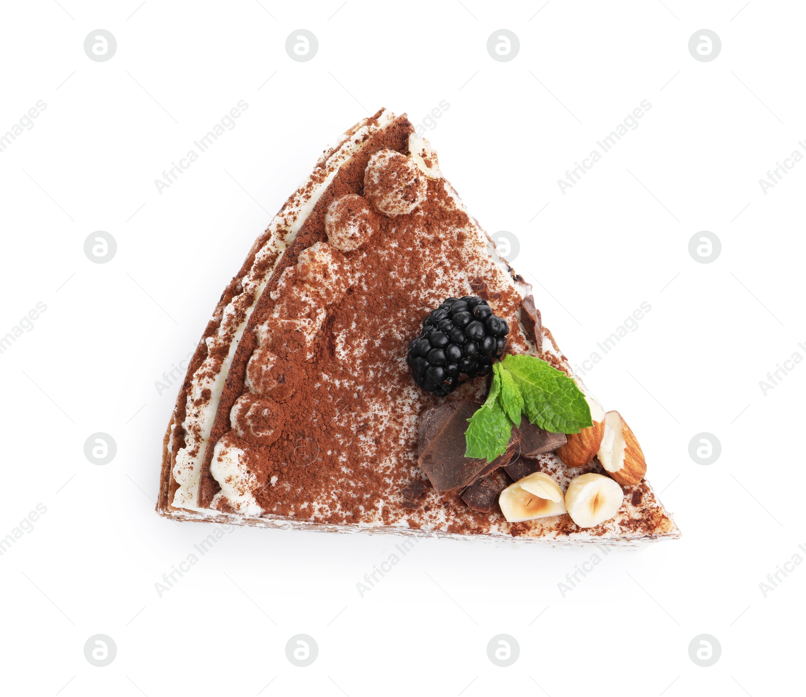 Photo of Piece of tasty crepe cake with cocoa powder, chocolate, nuts and blackberry isolated on white, top view