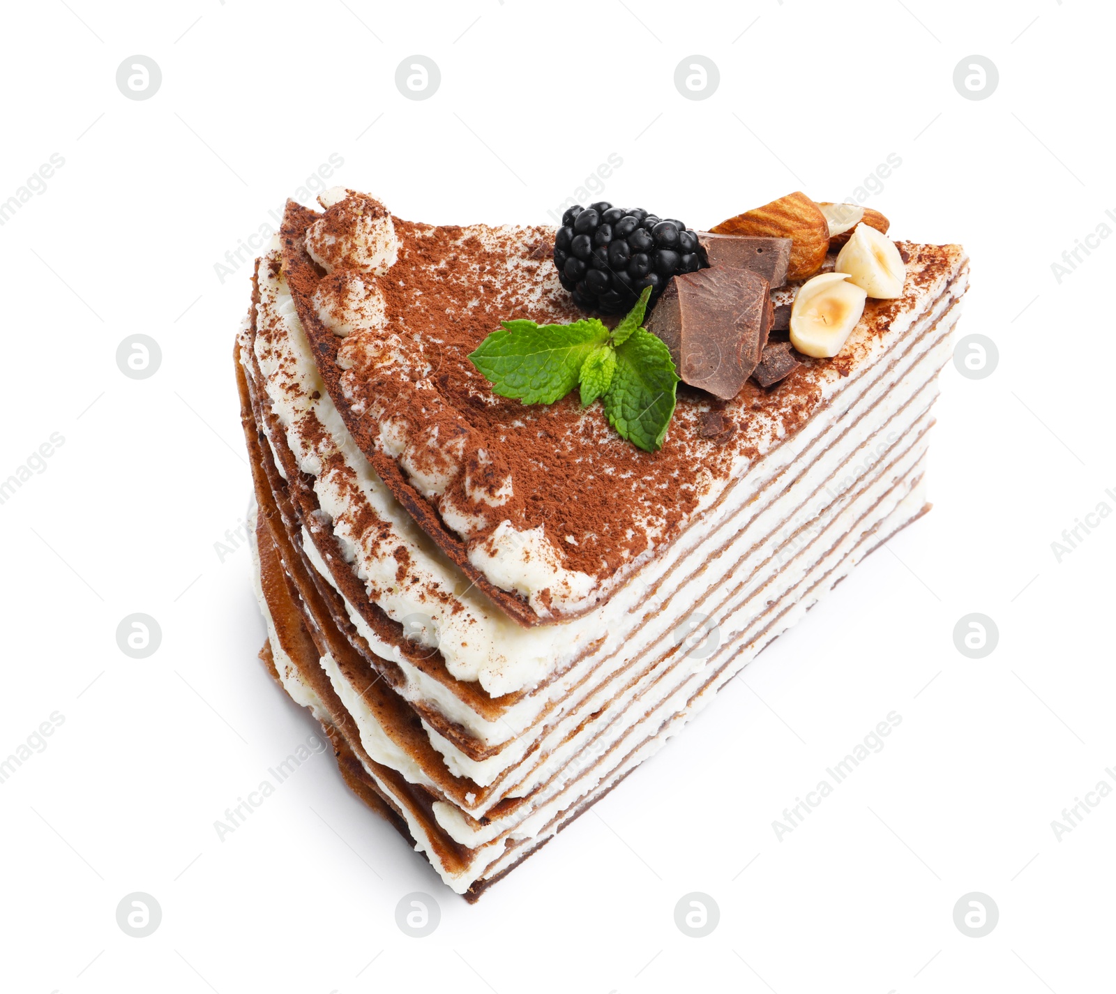 Photo of Piece of tasty crepe cake with cocoa powder, chocolate, nuts and blackberry isolated on white
