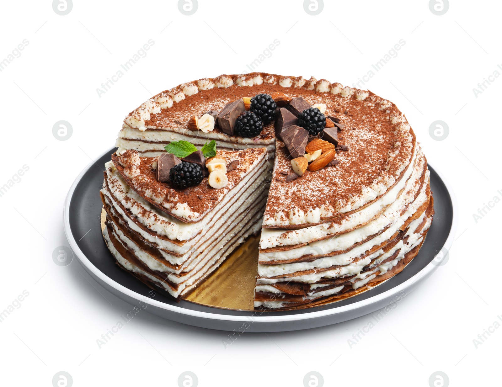 Photo of Tasty crepe cake with cocoa powder, chocolate, nuts, blackberries and mint isolated on white