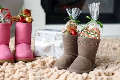 Photo of Saint Nicholas day tradition. Boots with sweets, festive decor and gift box on floor indoors