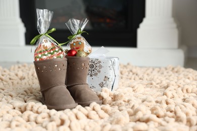 Photo of Saint Nicholas day tradition. Boots with sweets, baubles and gift box on floor indoors, space for text