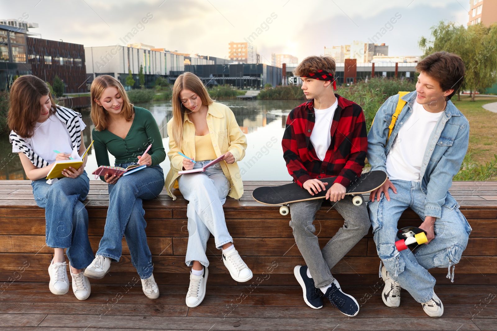 Photo of Group of teenagers doing homework together outdoors